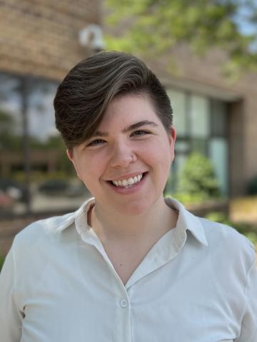 Headshot photo of Liv Alanis Myers, wearing a white shirt that has a collar. 