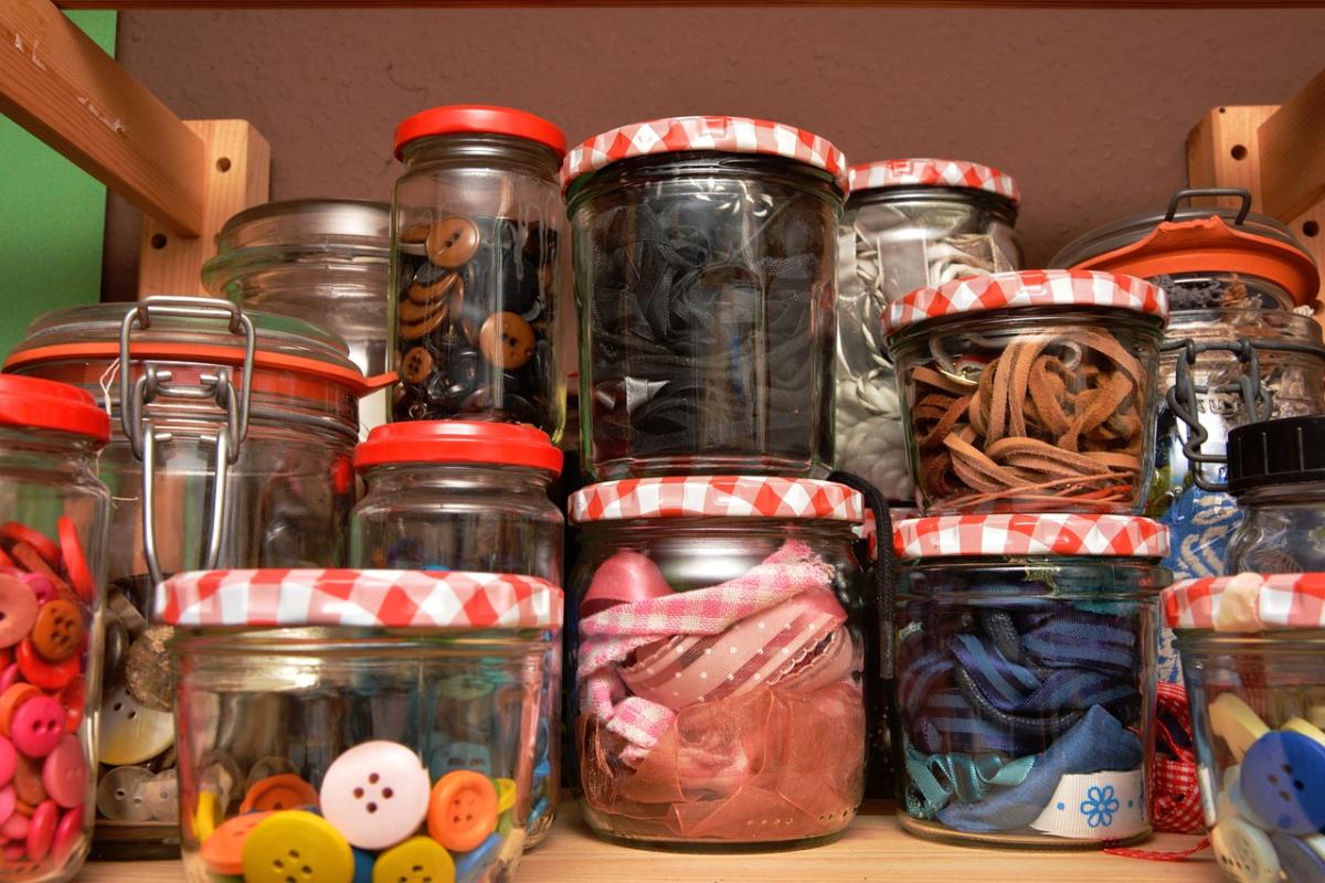 a variety of crafting supplies in glass jars