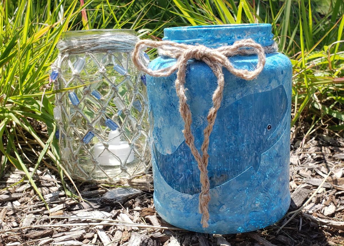 a painted jar lantern and a knotted jar lantern sitting on the ground