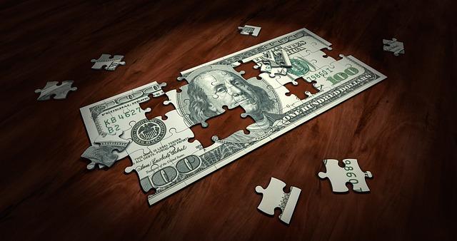 a wooden table with a jigsaw puzzle of a 100 dollar bill 