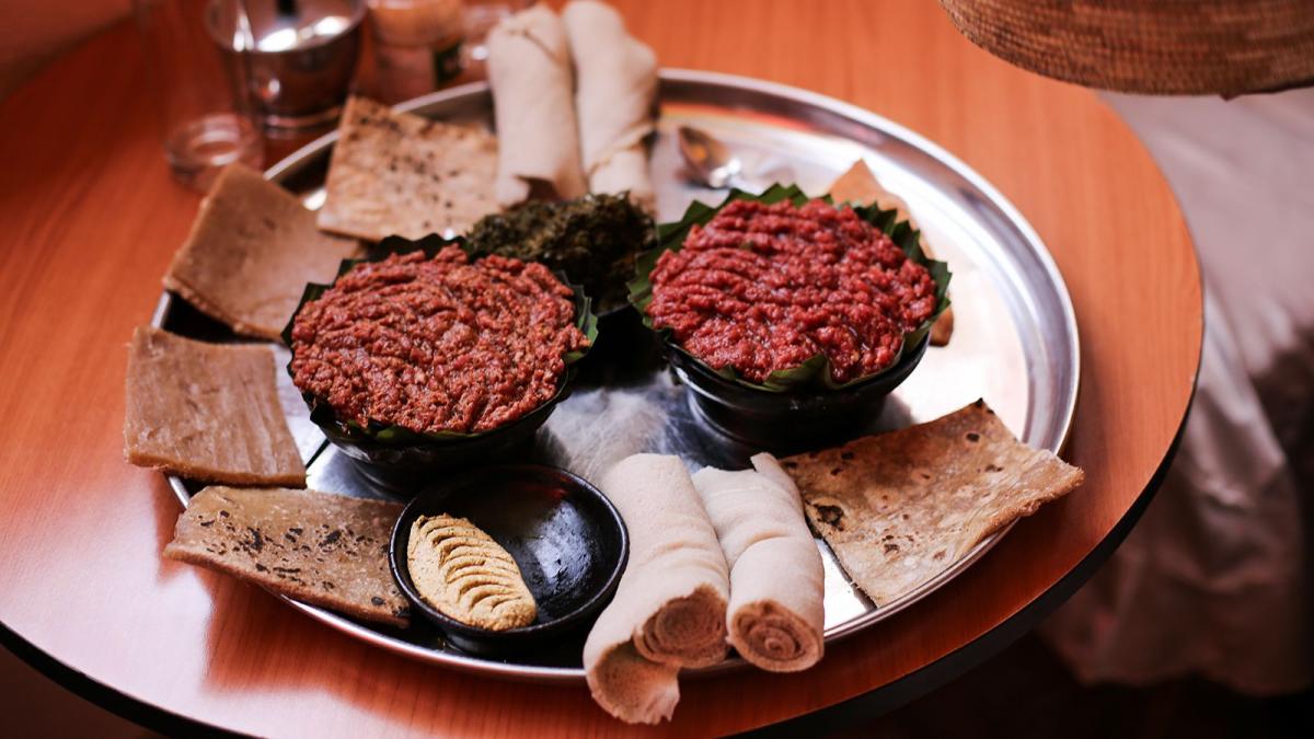 Plate with injera and various stews and preparations of traditional Ethiopian food