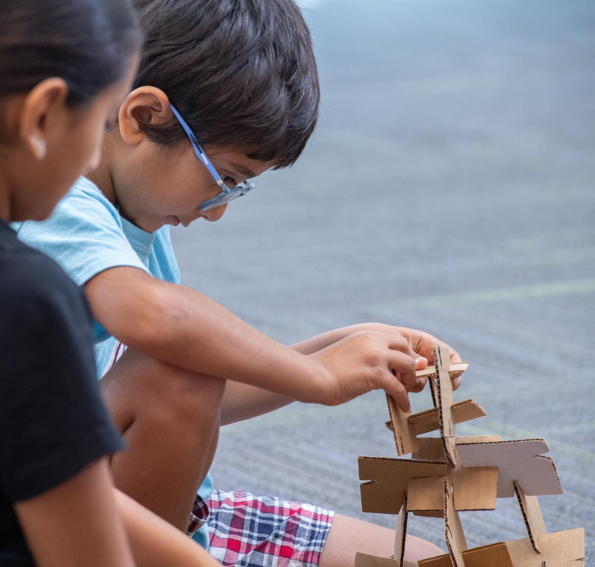 Children constructing with cardboard building squares