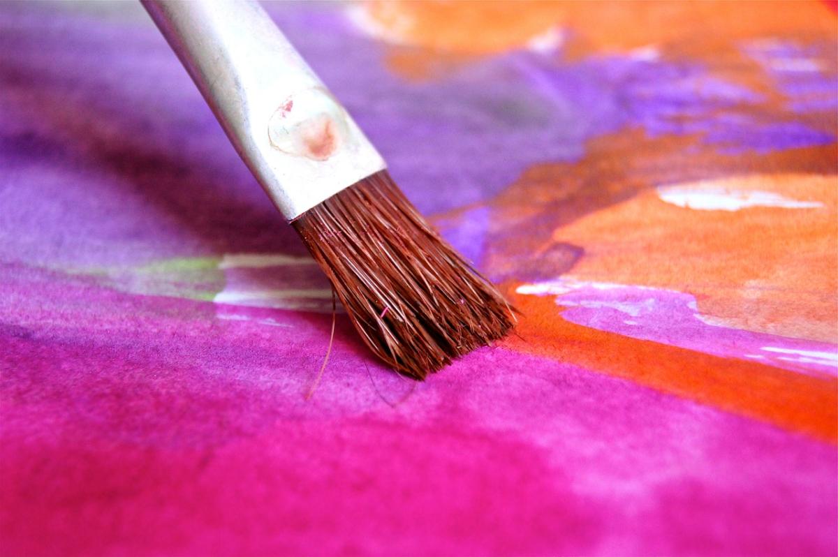 Paint brush with pinks, purples, oranges and white watercolors