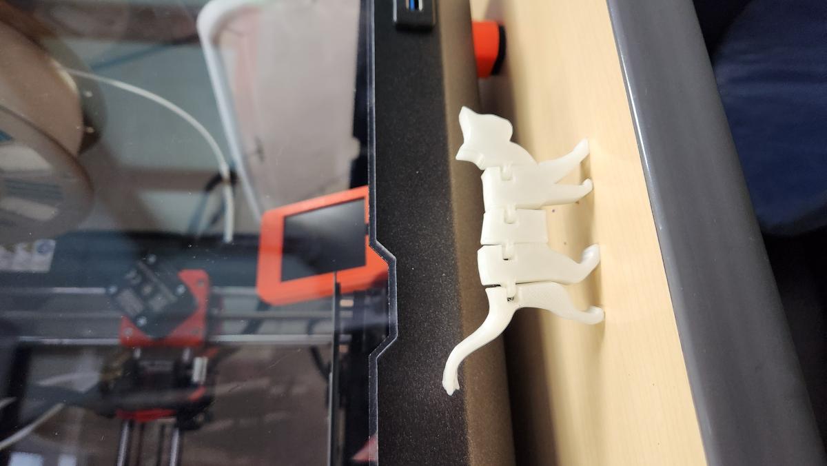 The image depicts a 3d-printed cat with articulated hinges.