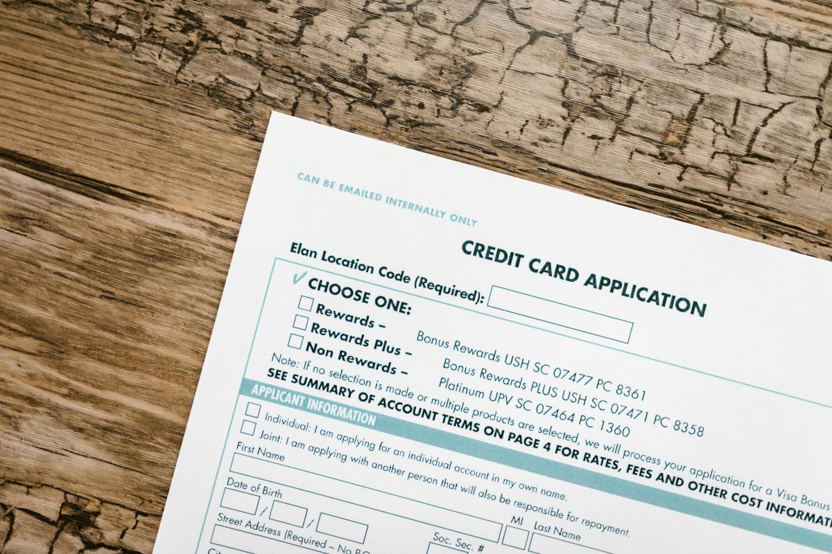 piece of paper titled 'credit card application' on a wood table